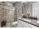 Elegant bathroom featuring granite vanity, glass enclosed shower with tile surround, and a decorative mirror at 12856 Sorrento Way, Bradenton, FL 34211