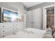 Modern bedroom featuring beach views on TV, a dresser, and multiple closets with ensuite bathroom at 12856 Sorrento Way, Bradenton, FL 34211