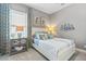 Inviting bedroom featuring nautical decor, a comfortable bed, and a bright window with stylish curtains at 12856 Sorrento Way, Bradenton, FL 34211