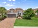 Charming single-story home with a tile roof, brick driveway, and lush landscaping at 12856 Sorrento Way, Bradenton, FL 34211