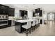 Modern kitchen boasting dark cabinetry, stainless steel appliances, and a large center island with seating at 12856 Sorrento Way, Bradenton, FL 34211