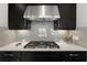 Modern kitchen backsplash with a gas stovetop and stainless steel range hood at 12856 Sorrento Way, Bradenton, FL 34211