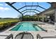 Relaxing screened-in pool and spa area with lounge chairs and tranquil lake view at 12856 Sorrento Way, Bradenton, FL 34211