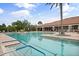 Inviting community pool with comfortable lounge chairs and a beautiful clubhouse in the background at 12856 Sorrento Way, Bradenton, FL 34211