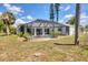 Backyard view of a home with a screened-in pool and spacious yard at 1304 Alton Rd, Port Charlotte, FL 33952