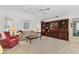 Cozy living room with a sofa, wingback chair, and a large built-in bookcase, illuminated by table lamps at 1304 Alton Rd, Port Charlotte, FL 33952