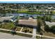 A high angle view showing a home with a waterfront canal, including a screened pool, mature trees, and a private boat dock at 149 Small Se St, Port Charlotte, FL 33952