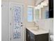 Bathroom with vanity, decorative glass door, tile backsplash and modern faucet at 149 Small Se St, Port Charlotte, FL 33952