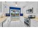 Modern kitchen featuring white cabinets, stainless steel appliances, and a view of the backyard pool area at 149 Small Se St, Port Charlotte, FL 33952