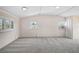 Bright living room features neutral paint, carpet, and multiple windows for natural light at 149 Small Se St, Port Charlotte, FL 33952