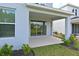Covered back porch with sliding glass doors that look out onto the lawn at 15033 Shady Palms Ln, Nokomis, FL 34275