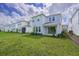 Back yard features lawn, covered porch, and home exterior at 15033 Shady Palms Ln, Nokomis, FL 34275