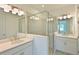 Modern bathroom featuring double vanity, sleek lighting, and a glass-enclosed shower at 15033 Shady Palms Ln, Nokomis, FL 34275