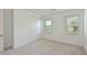 Bright bedroom with carpet, natural light from two windows, and a closet with sliding doors at 15033 Shady Palms Ln, Nokomis, FL 34275