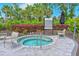 Community hot tub with mature landscaping and lounge seating at 15033 Shady Palms Ln, Nokomis, FL 34275