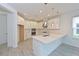 Bright, modern kitchen with white cabinetry, stainless steel appliances and an island with pendant lighting at 15033 Shady Palms Ln, Nokomis, FL 34275