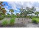 Community playground featuring a wooden climbing structure with palm trees in a landscaped area at 15033 Shady Palms Ln, Nokomis, FL 34275