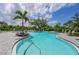 Community pool with ample lounge seating and lush tropical landscaping at 15033 Shady Palms Ln, Nokomis, FL 34275