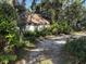 View of the charming single-story home surrounded by lush greenery at 1511 11Th W Ave, Palmetto, FL 34221