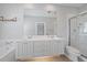 Bathroom with double sinks, bathtub and glass door shower at 1519 Napoli E Dr, Sarasota, FL 34232