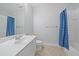Bright bathroom with a white vanity, blue shower curtain, and tile flooring at 1519 Napoli E Dr, Sarasota, FL 34232