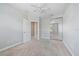 Light bedroom with neutral carpet and paint, ceiling fan, closet and entrance doors at 1519 Napoli E Dr, Sarasota, FL 34232