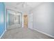 Bedroom featuring a mirrored closet, neutral carpet, ceiling fan, and a blue accent wall at 1519 Napoli E Dr, Sarasota, FL 34232