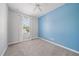 Cozy bedroom with a ceiling fan, plush carpeting, and a large window at 1519 Napoli E Dr, Sarasota, FL 34232