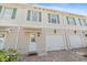 Townhouse with decorative shutters, brick driveway, and an attached garage at 1519 Napoli E Dr, Sarasota, FL 34232