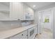 Kitchen with white appliances, white cabinets and tile floors that leads to a laundry room at 1519 Napoli E Dr, Sarasota, FL 34232