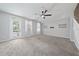 Spacious living room with carpet, ceiling fan, and access to outdoor balcony at 1519 Napoli E Dr, Sarasota, FL 34232