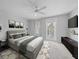 Staged main bedroom with ceiling fan, carpet flooring and a door that leads to a balcony at 1519 Napoli E Dr, Sarasota, FL 34232