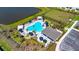 Aerial view of a sparkling community pool area with lounge chairs, cabanas, lush landscaping, and nearby parking at 16646 San Nicola Pl, Bradenton, FL 34211