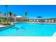 Community pool with lounge chairs, umbrellas, and a serene view, perfect for relaxation and recreation at 16646 San Nicola Pl, Bradenton, FL 34211