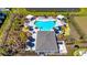 Aerial view of the pool and amenity center with lounge chairs, cabanas, lush landscaping, and adjacent parking at 16646 San Nicola Pl, Bradenton, FL 34211