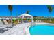 Community pool area featuring lounge chairs, a shaded cabana, and well-manicured landscaping at 16646 San Nicola Pl, Bradenton, FL 34211