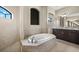 Luxurious bathroom with a soaking tub, a walk-in shower, and a large vanity with dual sinks at 1736 Suzi St, Punta Gorda, FL 33950