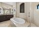 Bright bathroom featuring a soaking tub and a vanity with granite countertop at 1736 Suzi St, Punta Gorda, FL 33950