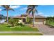 Beautiful home exterior showcasing lush landscaping, paver driveway, terracotta roof, and inviting curb appeal at 1736 Suzi St, Punta Gorda, FL 33950