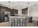 Modern kitchen featuring dark cabinets, stainless steel appliances, and a granite countertop bar with seating at 1736 Suzi St, Punta Gorda, FL 33950