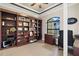 Office with custom built-in bookshelves, a ceiling fan, and a dark wood desk at 1736 Suzi St, Punta Gorda, FL 33950
