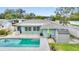 Aerial view of the backyard showcasing the pool, patio, shed, and green space at 1801 Forest Dr, Oldsmar, FL 34677