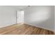 Minimalist bedroom featuring wood flooring, white walls, and open doorway at 1801 Forest Dr, Oldsmar, FL 34677