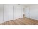 Bedroom with wood flooring, closets with sliding doors, and a white door at 1801 Forest Dr, Oldsmar, FL 34677