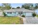 Lovely single-story home showcasing a tidy front yard, long driveway, and an attached garage at 1801 Forest Dr, Oldsmar, FL 34677