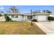 Charming single-story home with a well-maintained lawn, front garden, and attached one car garage at 1801 Forest Dr, Oldsmar, FL 34677