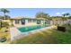 Backyard with a rectangular in-ground swimming pool surrounded by grass and patio at 1801 Forest Dr, Oldsmar, FL 34677