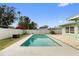 Backyard with a rectangular in-ground pool surrounded by well-maintained landscaping and a privacy fence at 1801 Forest Dr, Oldsmar, FL 34677