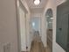 Hallway with neutral walls, light wood flooring, and arched doorways to bedrooms and other rooms at 1802 19Th W Ave, Bradenton, FL 34205
