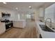 Bright, open kitchen featuring stainless steel appliances and a central island, all with updated wood flooring at 1802 19Th W Ave, Bradenton, FL 34205